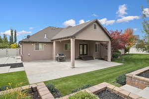 Rear view of property featuring a yard, ceiling fan, a patio, and stucco siding