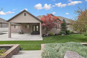 Rear view of property with a patio area, ceiling fan, stucco siding, entry steps, and french doors