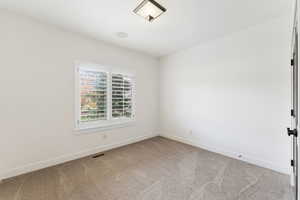 Unfurnished room with baseboards and light colored carpet