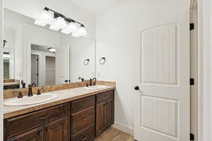 Full bathroom featuring light tile patterned flooring and double vanity