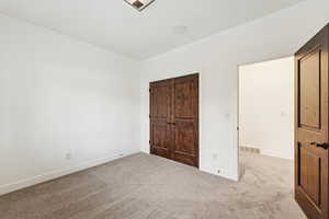 Unfurnished bedroom featuring carpet and a closet