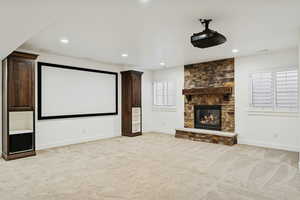 Cinema room with light carpet, a fireplace, and recessed lighting