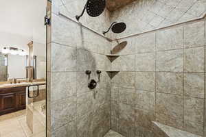 Bathroom featuring a shower stall, vanity, and tile patterned flooring