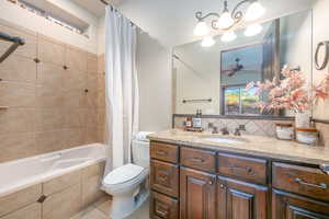 Full bath featuring vanity, tiled shower / bath combo, tasteful backsplash, and ceiling fan
