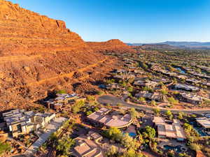 Aerial view of property and surrounding area with mountains and nearby suburban area
