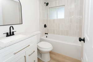 Bathroom featuring vanity, light wood-style flooring, and shower / bath combination