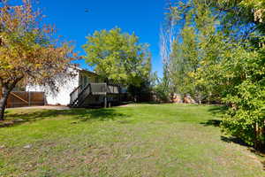 View of yard featuring stairway, a wooden deck, and a gate