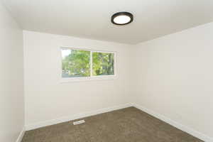 Spare room with carpet and baseboards
