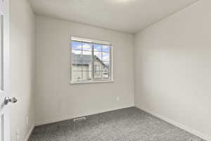 Spare room with carpet and baseboards