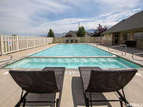 Community pool featuring a fenced backyard and a patio area