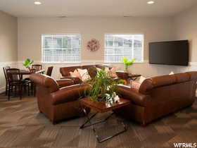 Living area with wainscoting, recessed lighting, and dark colored carpet