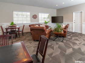 Living room with recessed lighting, dark colored carpet, and wainscoting