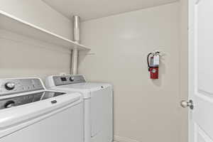 Washroom featuring washing machine and clothes dryer and baseboards