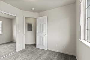 Unfurnished bedroom with carpet flooring and electric panel