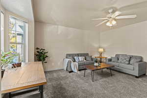 Living room featuring carpet floors and ceiling fan