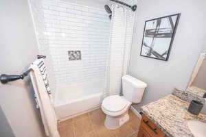 Full bath featuring light tile patterned floors, vanity, and shower / tub combo with curtain