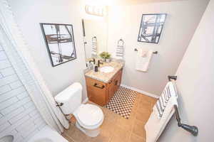 Full bath with light tile patterned flooring and vanity