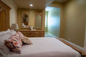 Bedroom with a textured wall and recessed lighting