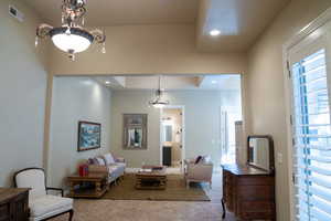 Living area featuring carpet, recessed lighting, and a chandelier