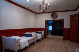 Bedroom with crown molding, carpet flooring, a wainscoted wall, a chandelier, and wood walls