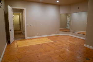 Empty room with light wood-style flooring and recessed lighting