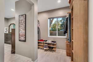 Corridor with light wood-style flooring and recessed lighting