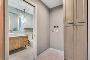Washroom featuring light wood finished floors, electric dryer hookup, washer hookup, and cabinet space
