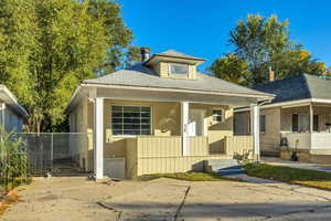 Bungalow-style home with a porch, roof with shingles, and brick siding