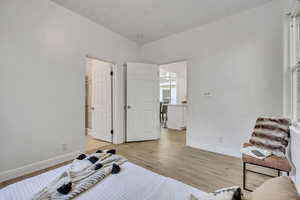 Bedroom with light wood finished floors and baseboards