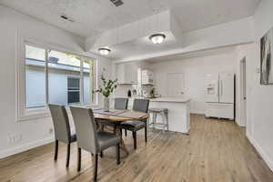 Dining room featuring light wood-style floors and a textured ceiling