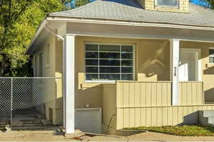 View of property exterior with a shingled roof and a porch