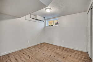 Below grade area with wood finished floors and a textured ceiling