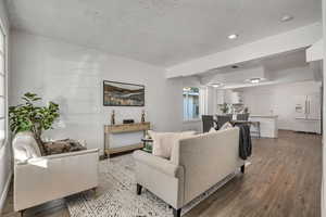 Living room featuring wood finished floors, recessed lighting, and a textured ceiling
