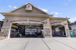View of front of property featuring stone siding, stucco siding, and driveway