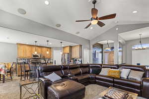 Living room with a ceiling fan, lofted ceiling, a chandelier, and recessed lighting