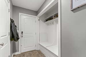 Mudroom with dark tile patterned floors