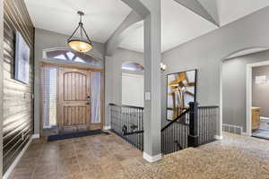 Foyer entrance with tile patterned floors and carpet flooring