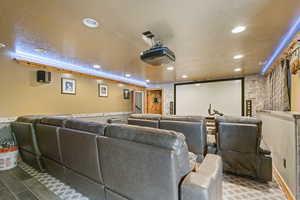 Cinema room featuring a textured ceiling, recessed lighting, and wood finished floors
