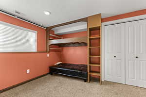 Unfurnished bedroom with carpet, a textured ceiling, and a closet
