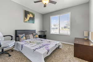 Carpeted bedroom featuring baseboards and ceiling fan