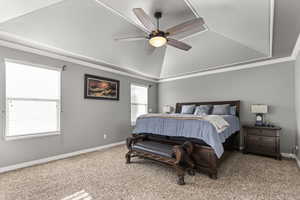 Bedroom with a tray ceiling, carpet flooring, ornamental molding, a ceiling fan, and lofted ceiling