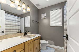 Bathroom with a shower with curtain, vanity, and light tile patterned floors