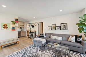 Living area with light wood-style flooring and recessed lighting