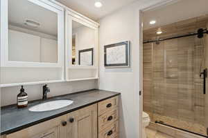 Full bath with vanity, a stall shower, and recessed lighting
