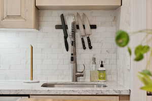Kitchen view of light stone countertops, light brown cabinets, and backsplash