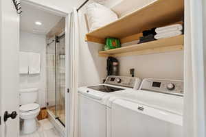 Washroom featuring washing machine and dryer, light tile patterned floors, and recessed lighting