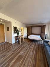 Bedroom with dark wood finished floors and a textured ceiling