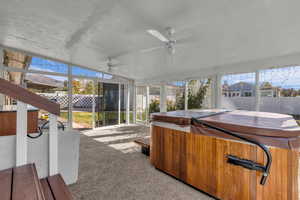 Sunroom with a jacuzzi, healthy amount of natural light, and a ceiling fan