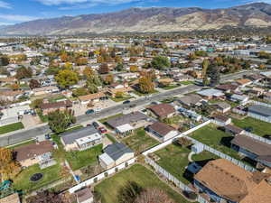Aerial view of property and surrounding area with mountains and nearby suburban area