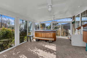 Sunroom with a jacuzzi, ceiling fan, and lofted ceiling